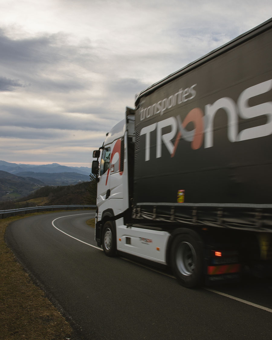 Parte delantera de un camión de Transova circulando por una carretera montañosa